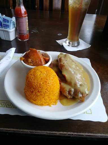 Smothered meat with gravy over yellow rice with candied yams and sweet tea